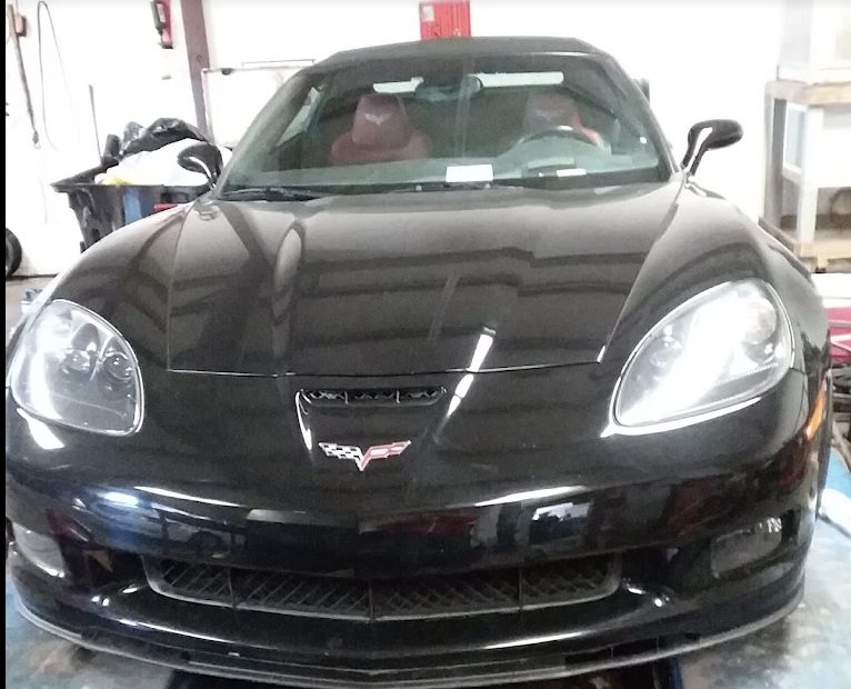 A black Corvette in a service bay at Rafa's Auto Repair