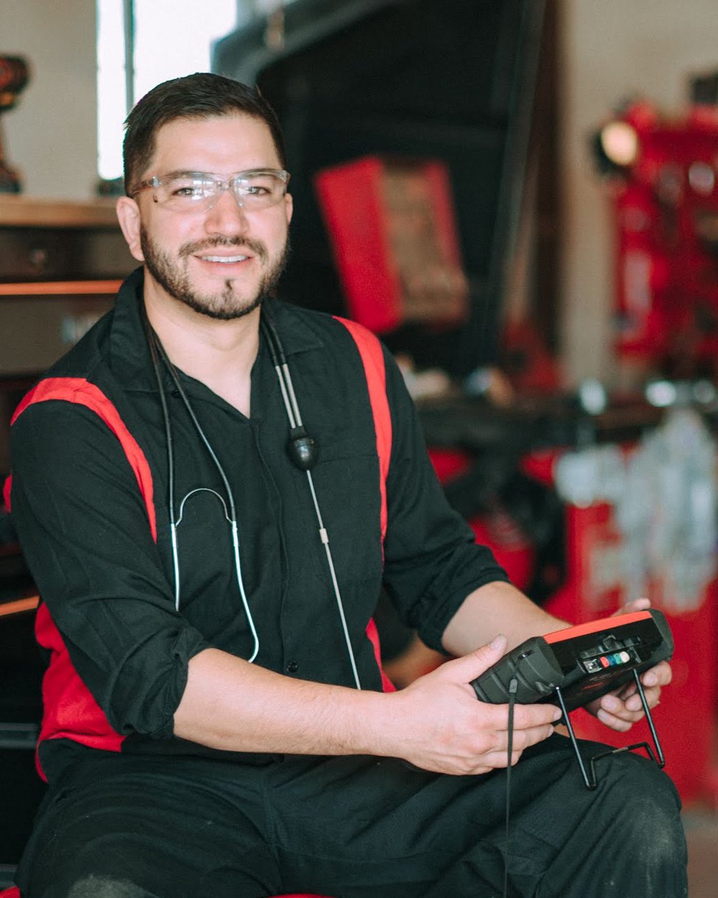 Rafael Muñoz, owner of Rafa’s Auto Repair, holding a diagnostic scan tool in his shop in Santa Fe